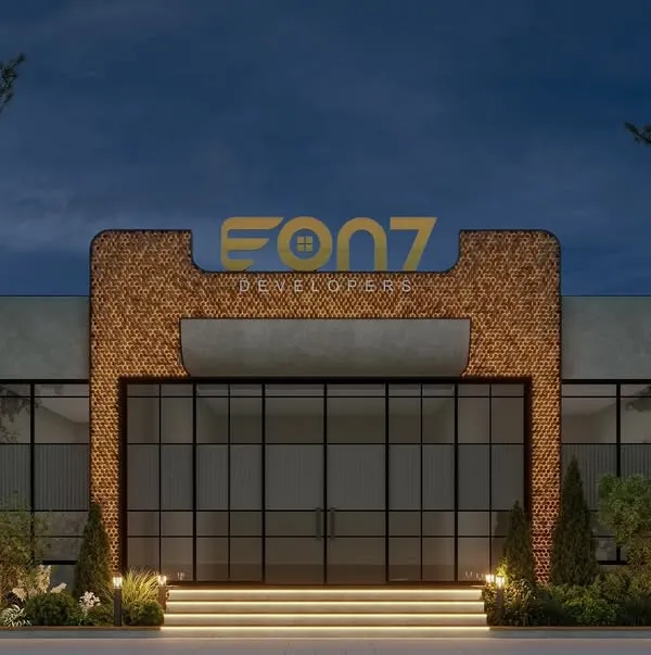 A straight-on view of the EON7 Developers facade in Gurugram, showcasing its modern, symmetrical design. The combination of textured surfaces, large glass panels, and integrated landscape design creates a powerful and welcoming entrance.