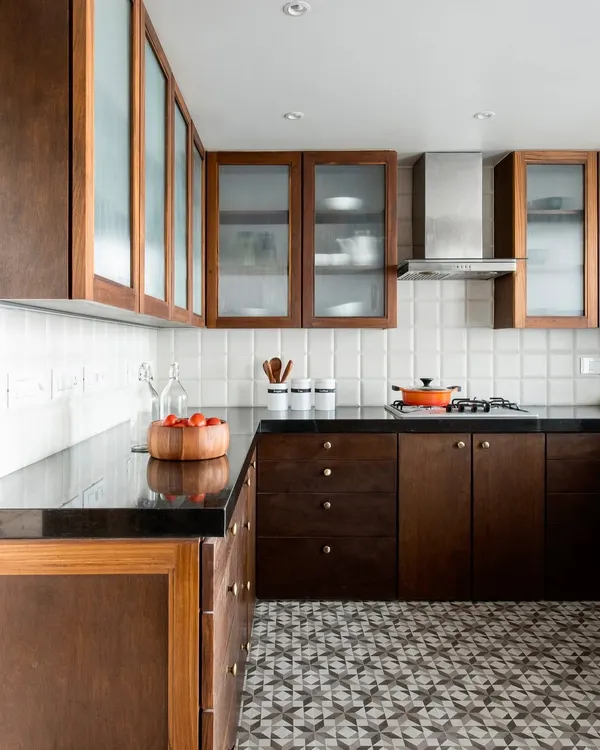 The kitchen in the Terrazzo Residence combines the warmth of wood with the graphic pattern of cement floor tiles. We used frosted glass on the upper cabinets to lighten the space and provide semi-concealed storage.