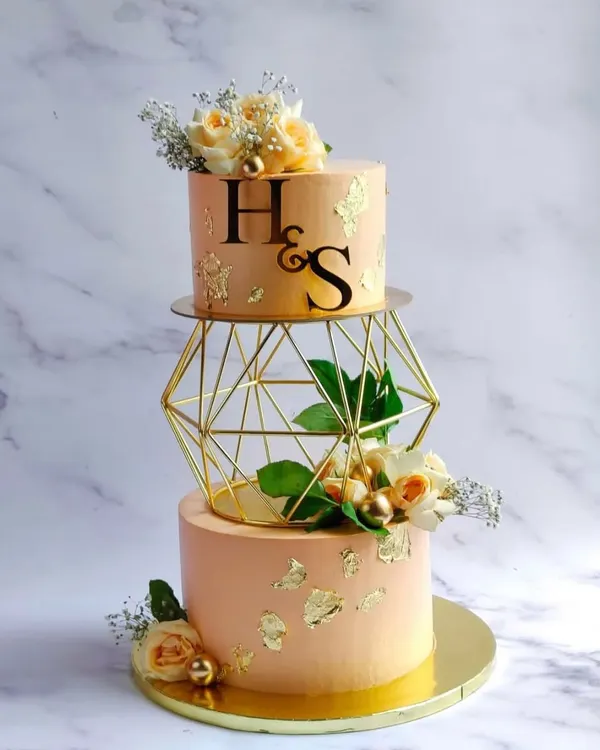 I loved creating this two-tier designer cake for H&S's engagement. It features a delicate peach frosting, real gold leaf accents, and fresh flowers, all completely vegetarian. A cake like this becomes the centerpiece of your celebration.