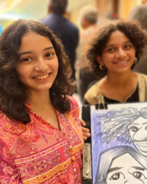 Two young girls with their group caricature at the Sheraton Grand Pune. It's a fun souvenir for friends to share.