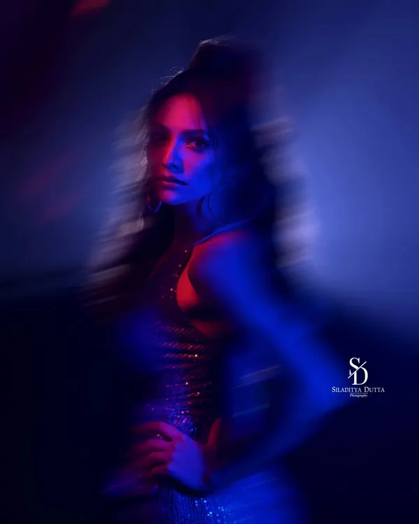 An abstract portrait using motion blur and colored gels. The streaks of red and blue light create a sense of energy and movement, resulting in a dynamic and artistic image.