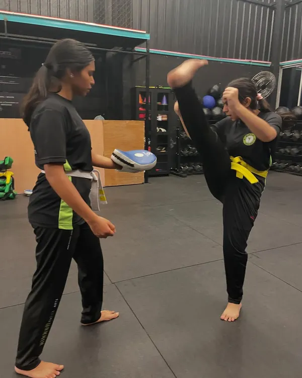 A fantastic high kick demonstrates the power and flexibility we build in our classes. This student is practicing her technique on the pads, focusing on height and form.