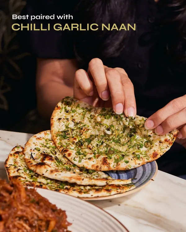 There's nothing quite like tearing into a piece of our Chilli Garlic Naan. Fresh from the tandoor and generously topped with garlic and herbs, it's the perfect partner for our slow-cooked Raan Musallam.