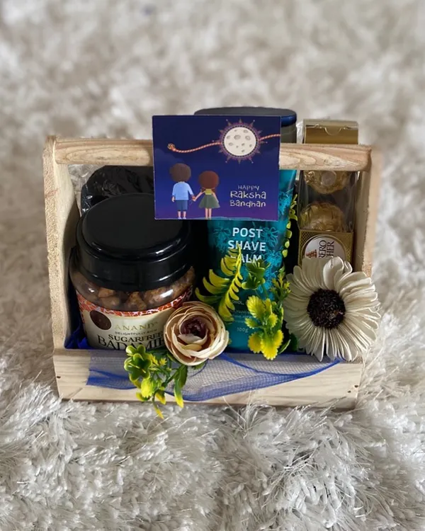A thoughtful Rakhi hamper curated especially for a brother. This gift set includes men's grooming products like post-shave balm, paired with delicious Ferrero Rocher chocolates and gourmet nuts, presented in a rustic wooden crate.