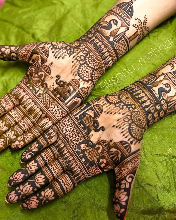 A stunning example of traditional bridal mehndi, with both hands covered in dense, intricate patterns. This design features classic motifs like elephants, peacocks, and lotuses, perfect for a grand wedding celebration.