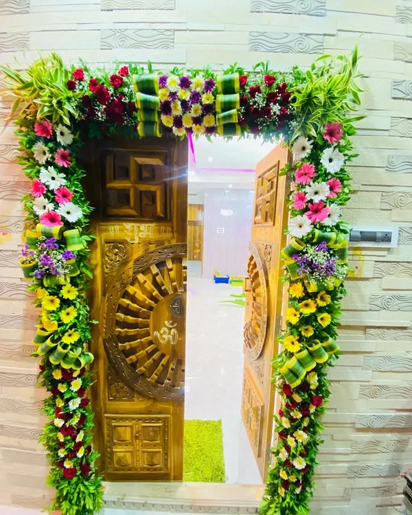 This grand floral arch is designed to make a statement. It's built with a base of fresh green leaves and decorated with a variety of colorful flowers, creating a stunning and festive entryway.