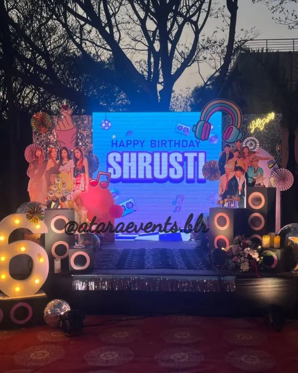 The stage is set for a K-Pop superstar! This 16th birthday bash features a large LED screen, speaker props, and '16' marquee lights, creating a concert-like atmosphere for a night of music and dancing.