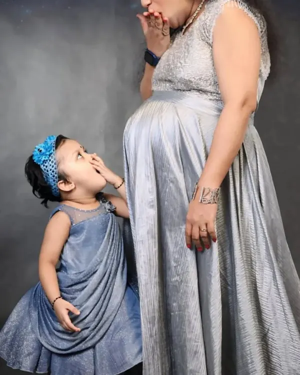A precious moment between a mother and her daughter. I created this matching set with a silver maternity gown for the mom and a cute grey frock for the little one.