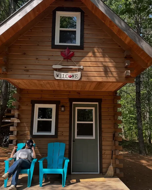 A relaxing moment at a cozy cabin. This shot captures a peaceful, rustic vibe, perfect for brands in the travel, wellness, or comfort apparel space.