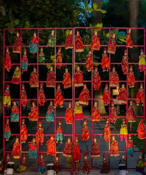 A unique and artistic decor element featuring a grid of colorful puppets, adding a touch of traditional Rajasthani craft to the wedding decor.