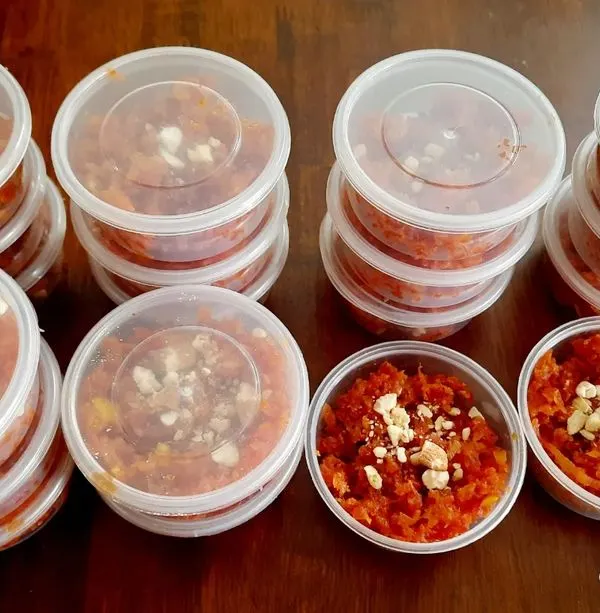 Stacks of my homemade carrot halwa, packed in individual containers for a party order. This makes serving dessert easy and ensures every guest gets a fresh portion.