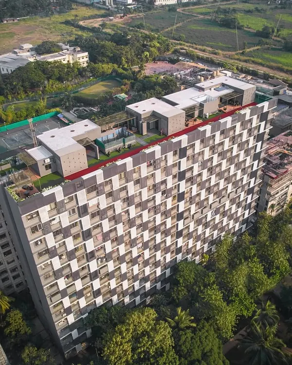 The DLH Mamta residential redevelopment project in Upper Juhu, Mumbai. The design features a striking zigzag facade of aluminum louvers, which adds a sense of movement and reduces the visual bulk of the structure while maximizing views over the adjacent green spaces.