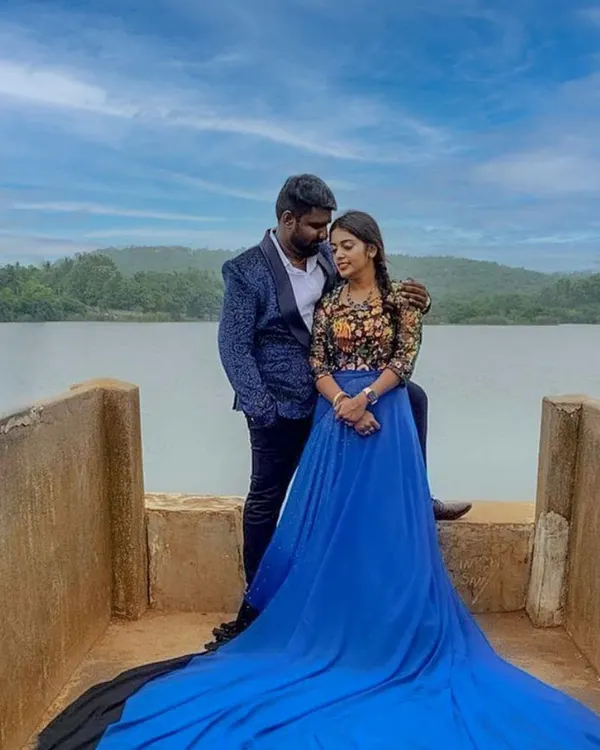 This scenic lakeside shot highlights one of our popular pre-wedding rental packages. The royal blue trail gown and coordinated blue patterned blazer create a cohesive and visually striking look for any couple's photoshoot.