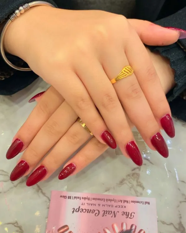A classic and powerful look with long, stiletto-shaped nails in a glossy, deep red polish. This timeless choice is always in style.