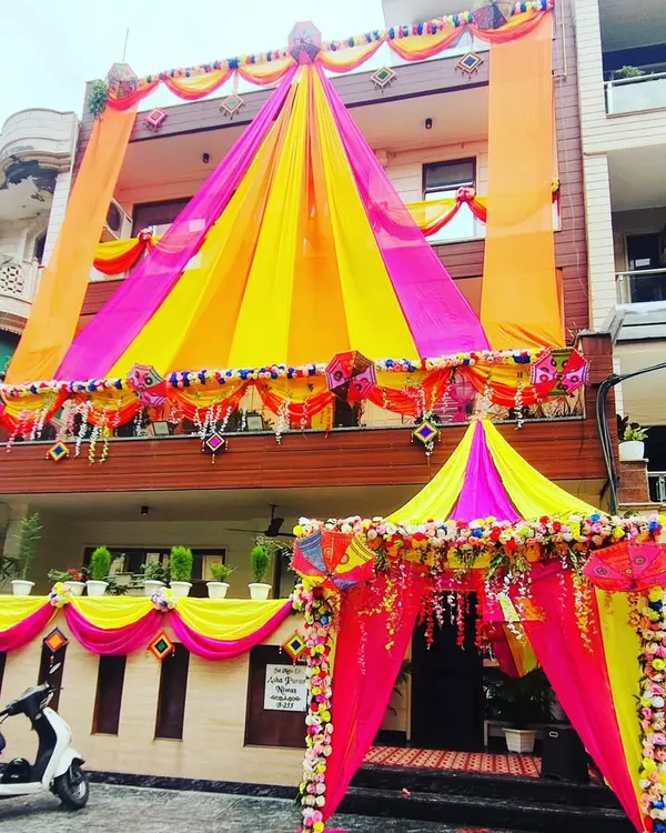 I specialize in turning your house into a true 'shaadi wala ghar'. This full-building transformation uses a vibrant combination of yellow and pink drapes, complete with a beautiful canopy entrance to welcome your guests in style.