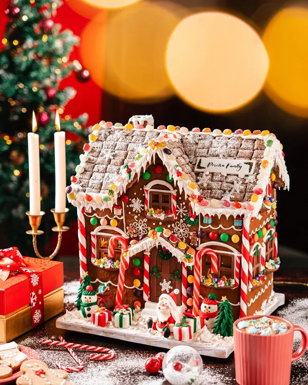 A magnificent, fully edible Gingerbread Mansion, intricately detailed with candy canes, snow-dusted roofs, and festive characters. This is a centerpiece that embodies the magic of celebration, handcrafted to create unforgettable holiday memories.