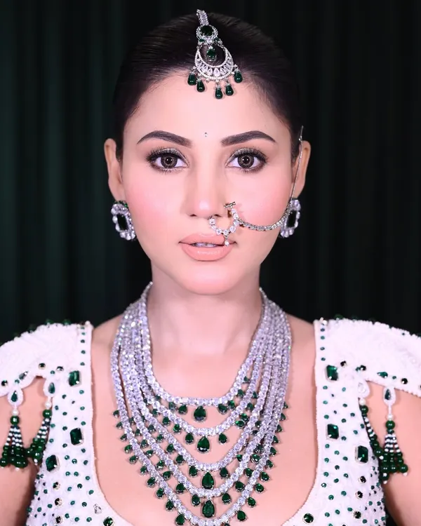 A close-up of a classic bridal look, focusing on the soft glam eye makeup and perfectly defined nude lips. The right jewelry placement, like the maang tikka and nath, enhances the entire face.