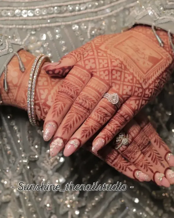 A beautiful shot of my bridal nail art, designed to perfectly complement the intricate henna. This set features a soft pink base with 3D flowers and a delicate sugar glitter effect.