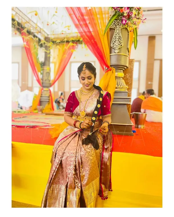 A stunning magenta velvet blouse with detailed embroidery on the sleeves. This blouse was paired with a traditional silk saree for a rich and royal wedding look.