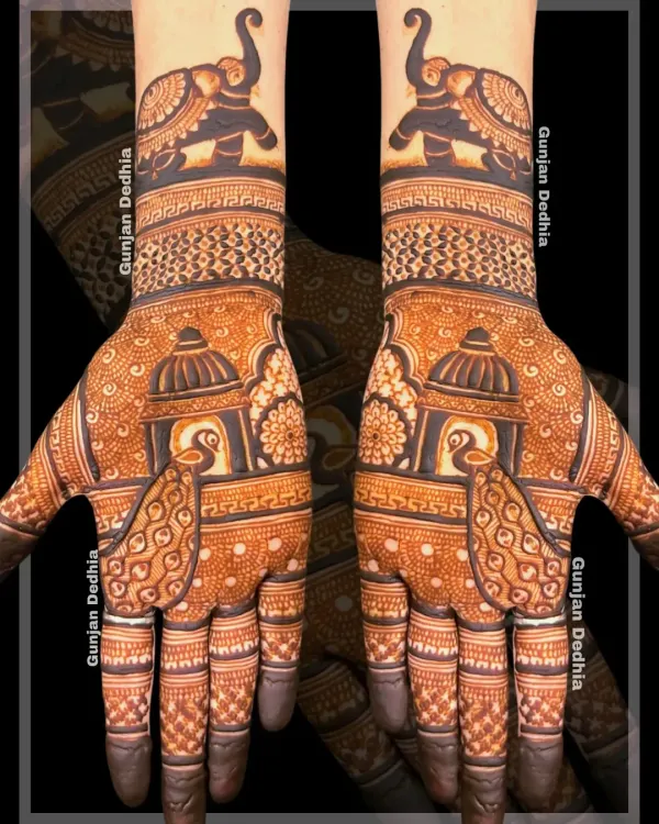 A stunning example of symmetrical traditional mehendi. Both hands feature a mirror design of peacocks in a jharokha and elephants on the wrists, creating a balanced and regal look.