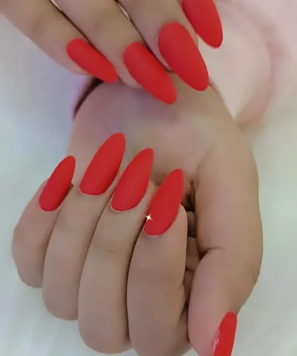 A classic and bold look featuring long almond nails with a flawless matte red finish.