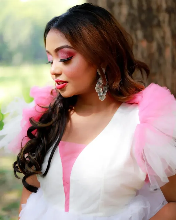 A close-up from the pink gown editorial shoot. The makeup features a bright pink eyeshadow with a sharp black wing, complementing the dress and creating a fresh, vibrant look.