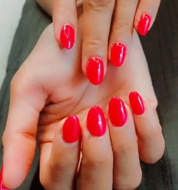 A classic and confident choice. This is a simple manicure with a vibrant, glossy red gel polish on perfectly shaped oval nails.