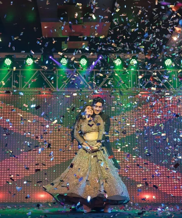 A magical moment under a shower of confetti. This shot captures the grand finale of the couple's Sangeet performance, full of romance and celebration.