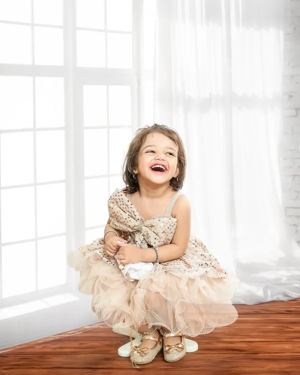 A moment of pure, unscripted laughter. This classic portrait against a bright, clean background focuses entirely on her joyful expression.