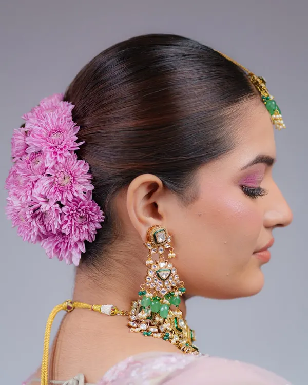 A side profile of this gorgeous floral bun, showing how the fresh flowers are carefully placed to complement the bride's jewelry and makeup.