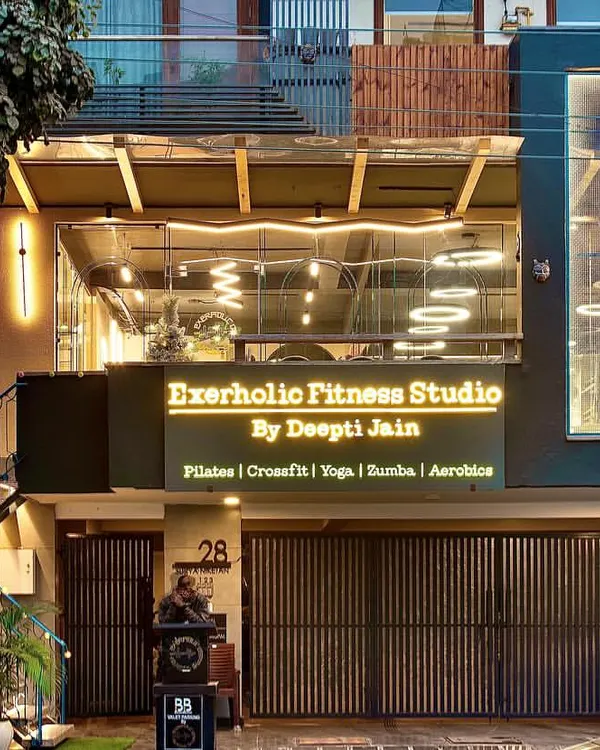 A full view of our studio facade at dusk. We wanted to create a space that looks as good on the outside as it feels on the inside. You can see our offerings listed right on the front: Pilates, CrossFit, Yoga, Zumba, and Aerobics.