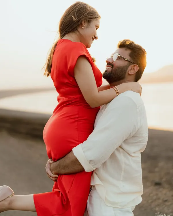 A joyful lift against the golden light of sunset at Aamby Valley. This image is full of warmth, happiness, and the beautiful glow of love.