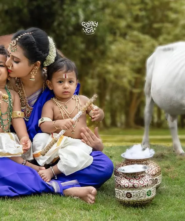 A mother's love is the purest form of devotion. Here, with her two little Krishnas, we captured a moment of unending love, set against a serene, pastoral backdrop.
