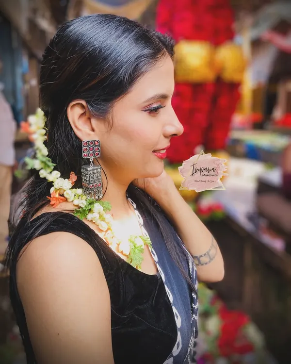 A beautiful side profile from a "market theme" photoshoot. The makeup is natural and sunkissed, with fresh flowers in the hair to complement the vibrant setting.