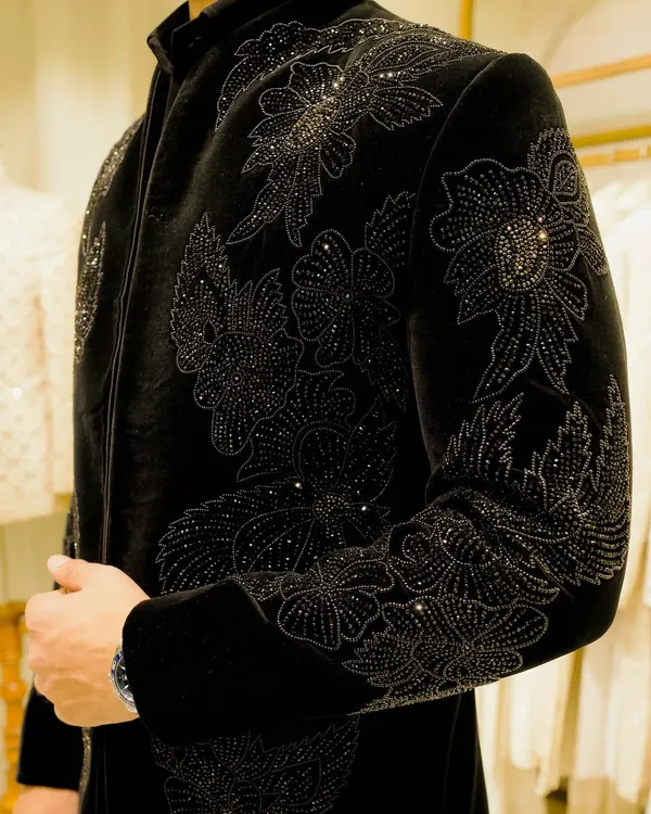 A close-up of the black-on-black floral embroidery on a velvet bandhgala. The intricate beadwork and thread create a subtle, luxurious texture that defines our craftsmanship.