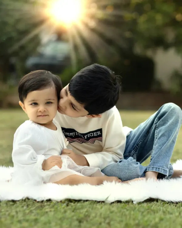 A tender moment between brothers in the golden afternoon sun. This outdoor sibling photoshoot captures the sweet, protective bond they share.