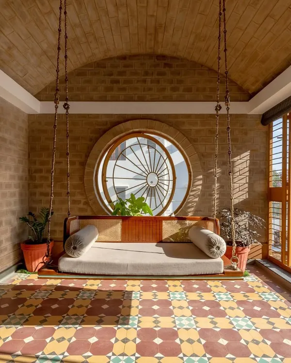 This is Audumbara, a home that truly represents my design philosophy. We used compressed earth blocks made on-site, a vaulted roof, and traditional patterned tiles to create a space that is both sustainable and soulful. The swing room, bathed in sunlight, is a perfect example of how I design spaces for quiet joy.