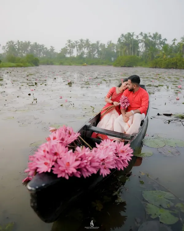 A truly magical moment on the water, surrounded by pink water lilies. This is the kind of serene, fairy-tale setting we can find for your pre-wedding photoshoot in the backwaters of Kerala.
