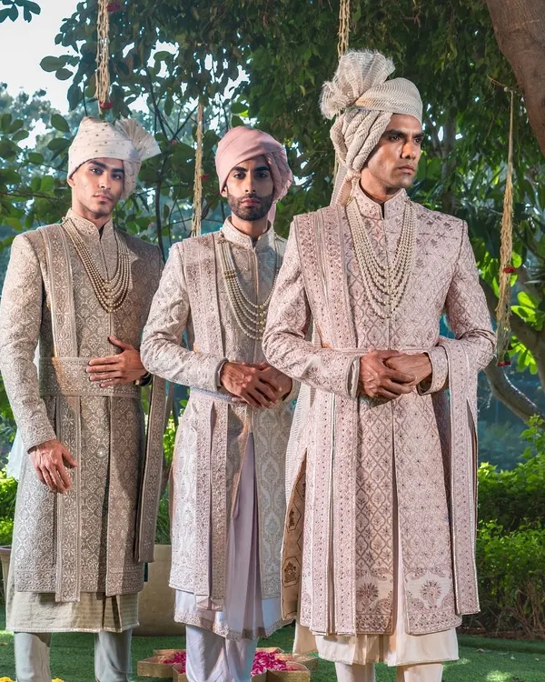 A portrait of royal elegance, this trio of groomsmen and groom showcases our ability to create a cohesive wedding party aesthetic. Each sherwani, complete with a traditional safa, is a masterpiece of coordinated design and individual tailoring.