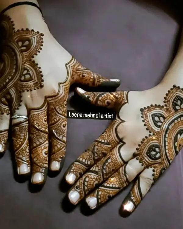 A beautiful example of a modern Arabic design. The pattern flows gracefully across the back of the hands, using negative space to create a delicate, jewelry-like effect.