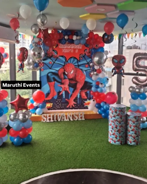 A full-scale Spiderman celebration for a 5th birthday. This setup includes a large city-scape backdrop, multiple Spiderman balloon figures, and themed columns, creating an immersive New York City for the little hero.