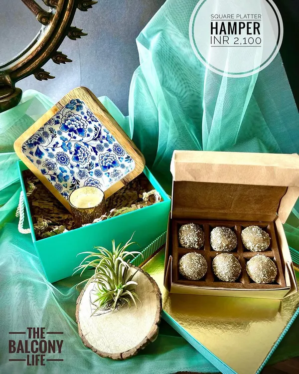 Our Square Platter Hamper is a festive favorite for Diwali. The stunning blue and white enamel platter is perfect for serving sweets, and it comes with a box of treats made from upcycled grains. We also include an air plant in a natural wood holder to add a touch of living green to the celebration.