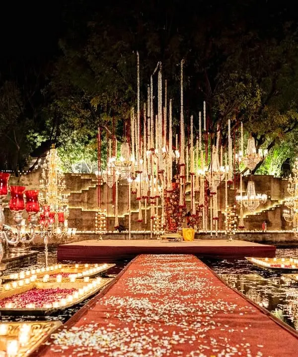 We transformed the stunning Alila Bishangarh into a dreamscape of light and water. This floating mandap, surrounded by thousands of candles, was our answer to an evening of unpredictable rain, creating a magical, cinematic setting for a truly unforgettable wedding.