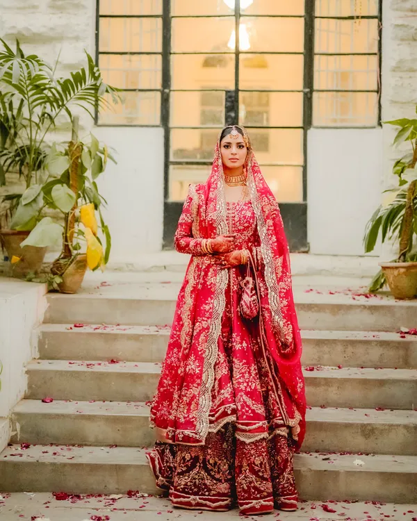 Here is a bride embodying pure grace and elegance on her Nikah day. Her magnificent red lehenga stands out against the timeless stone architecture, creating a portrait that is both regal and deeply personal. I believe in capturing the bride's individual story and presence in a way that feels majestic.