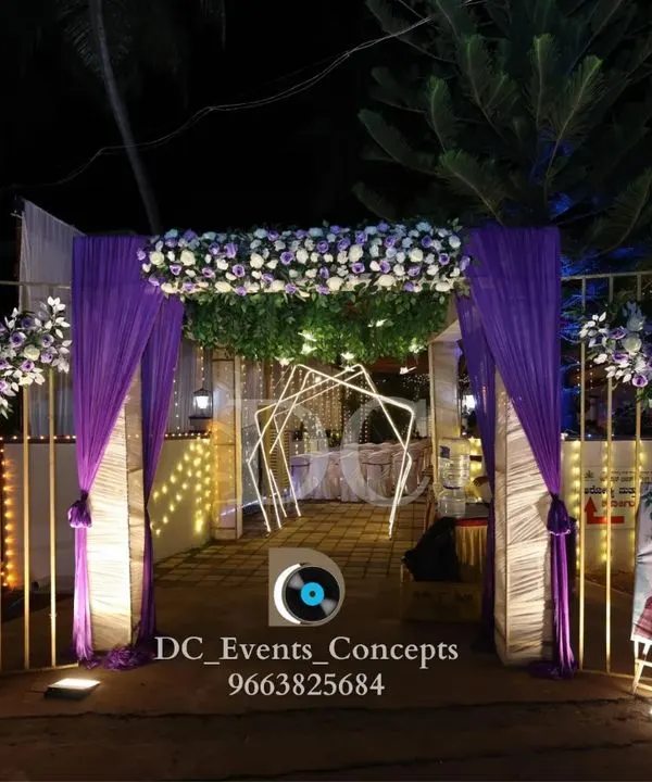 A beautiful entrance for a Roce ceremony, featuring purple drapes, white and purple floral arrangements, and a personalized welcome sign for the bride-to-be.