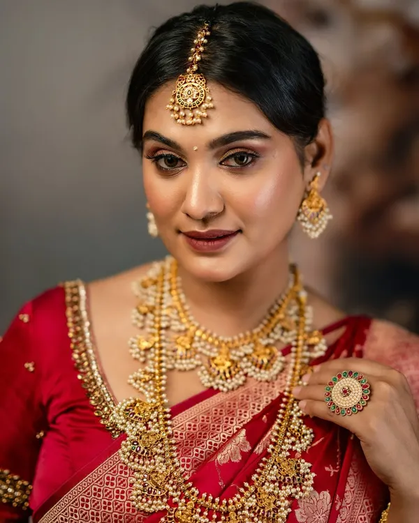 This is one of my favorite bridal looks. The layered antique gold necklaces, detailed maang tikka, and matching jhumkas create a complete, regal appearance for a South Indian bride. It’s available to rent for your muhurtham or wedding ceremony.