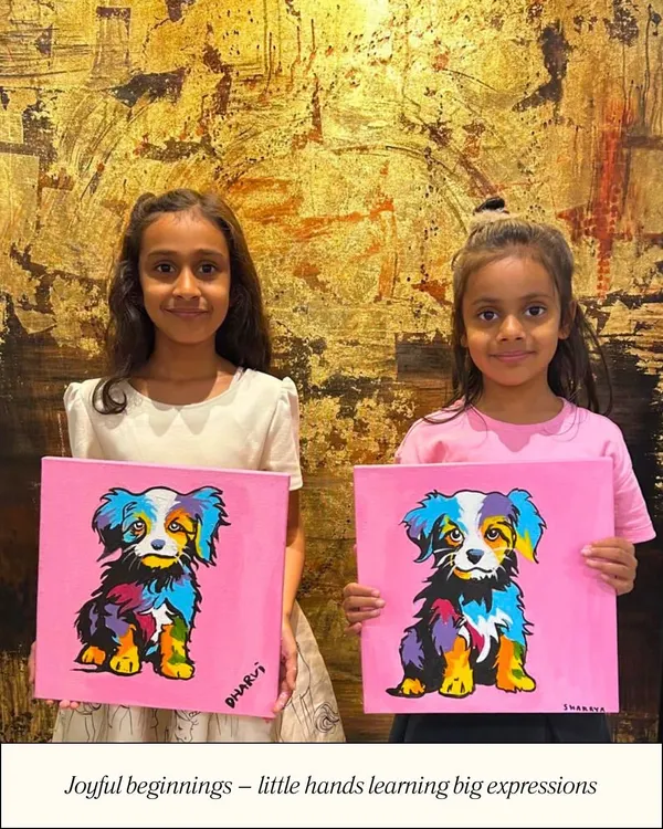Joyful beginnings start here, where little hands learn big expressions. These two young artists are proudly holding up their colorful pop-art style dog paintings.