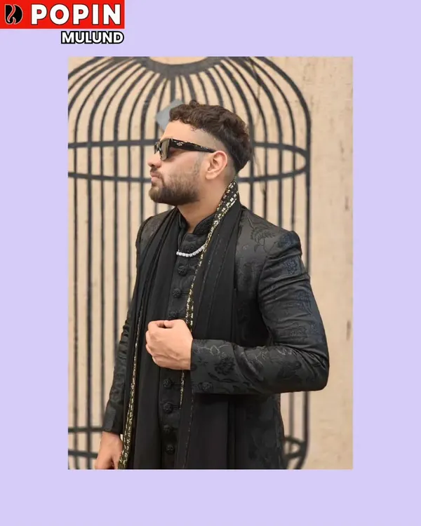 This is a perfect example of modern fusion wear. A client is wearing a black Indo-Western jacket with a matching draped kurta and a stylish scarf.