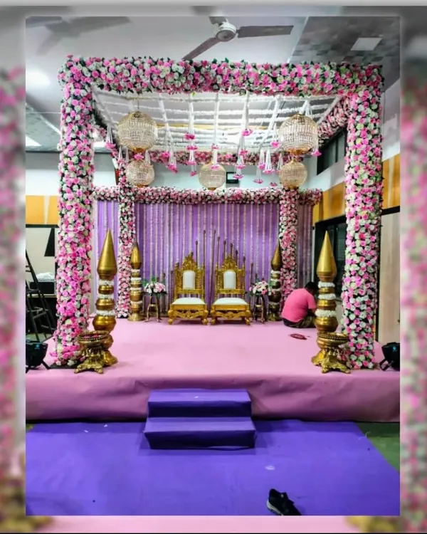 A fairytale mandap for a memorable ceremony. This square mandap is heavily decorated with pink and white flowers, featuring elegant birdcage chandeliers that add a touch of whimsy and romance to the wedding rituals.