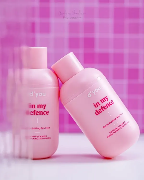 A creative shot of a pink moisturizer bottle, using motion blur effects in the foreground to draw the eye. This technique adds a dynamic and artistic feel to a standard product photo.